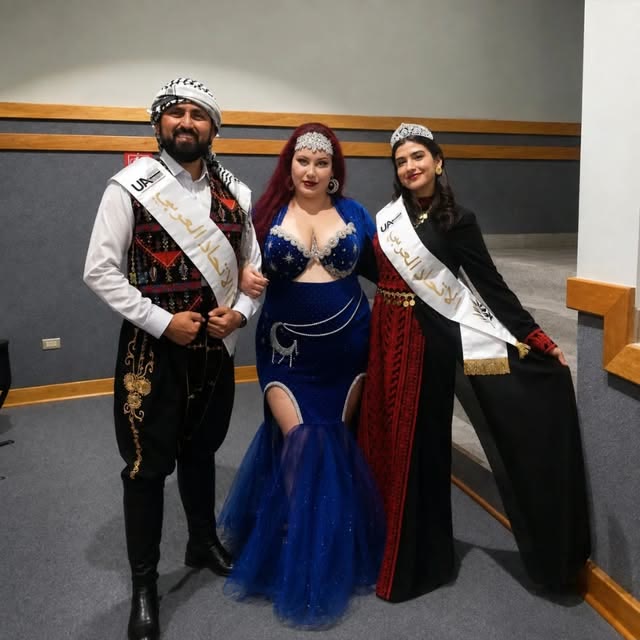 Luna junto a ganadores con bandas en un certamen de danza árabe